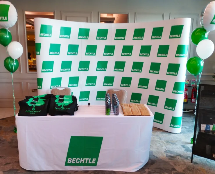 White and green Bechtle stand with balloons and branded merchandise