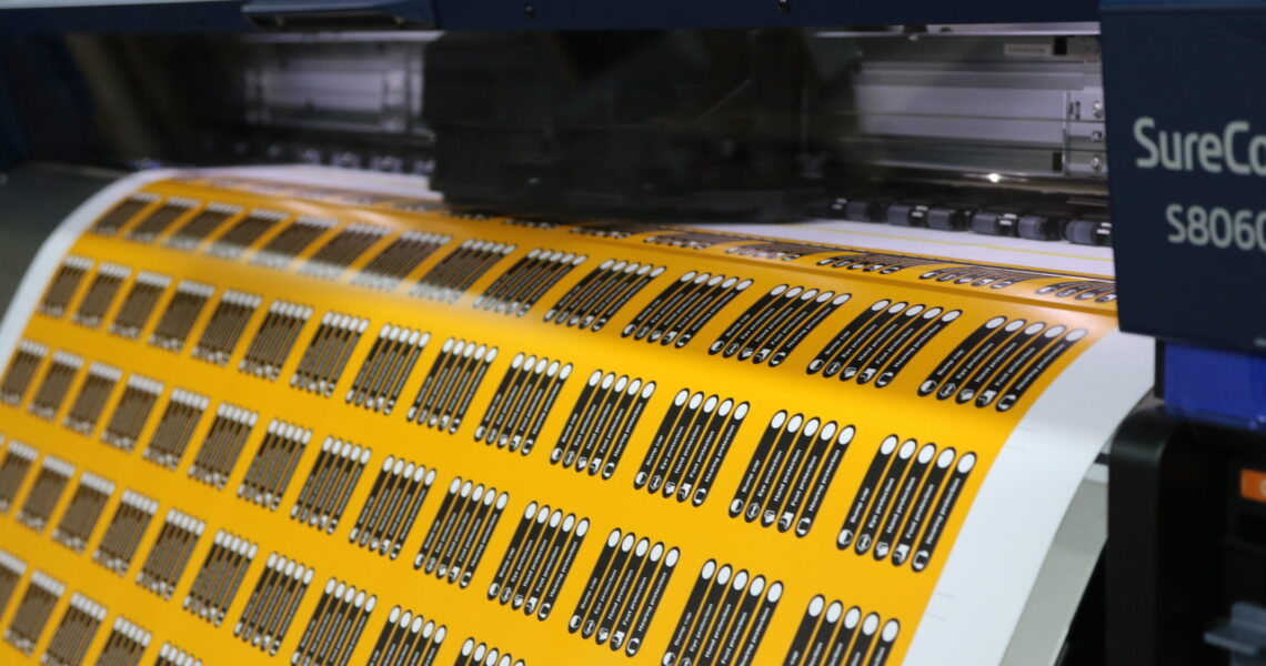 commercial printer printing out yellow and black labels