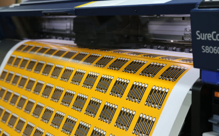 commercial printer printing out yellow and black labels
