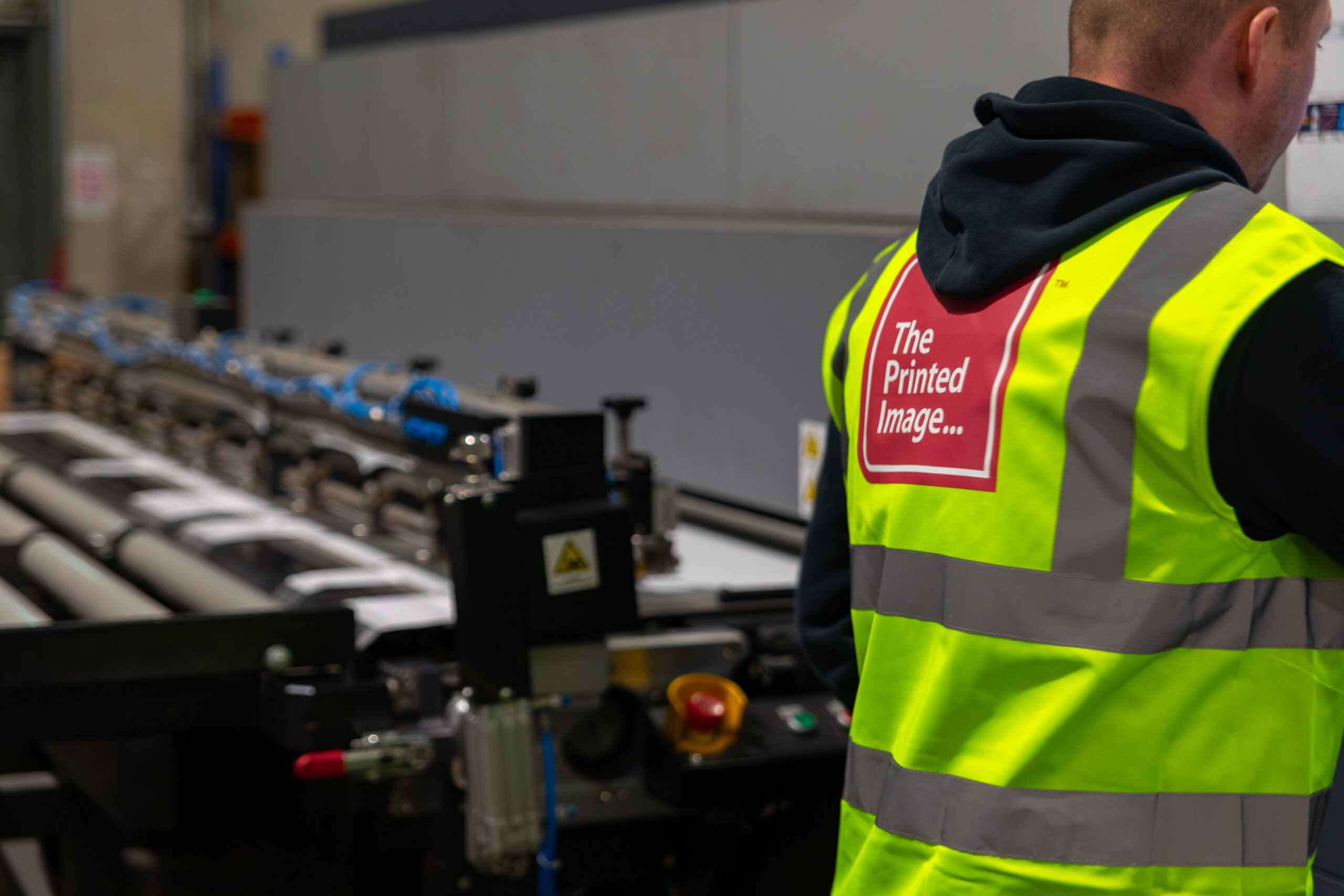 a man in a high viz vest operating a printer