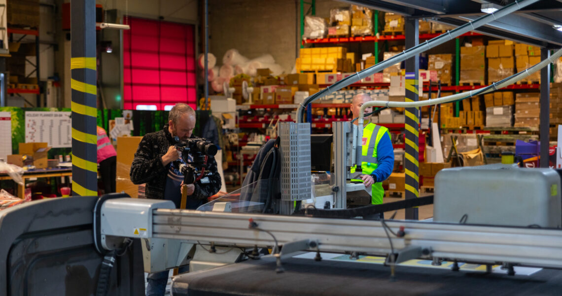 printing factory with a camera man recording the keyline machine
