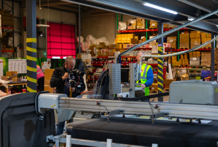 printing factory with a camera man recording the keyline machine